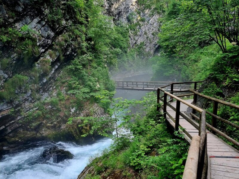 Paar wandert durch die Vintgar-Klamm in Slowenien im Sonnenlicht