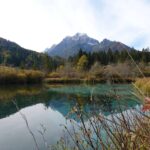 Zelenci-See im Naturreservat mit klarem Wasser und Bergen im Hintergrund