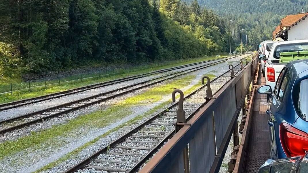 auto und fahrgäste auf dem autozug in slowenien, landschaft und berge im hintergrund