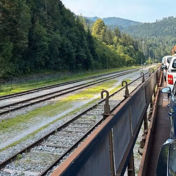 auto und fahrgäste auf dem autozug in slowenien, landschaft und berge im hintergrund