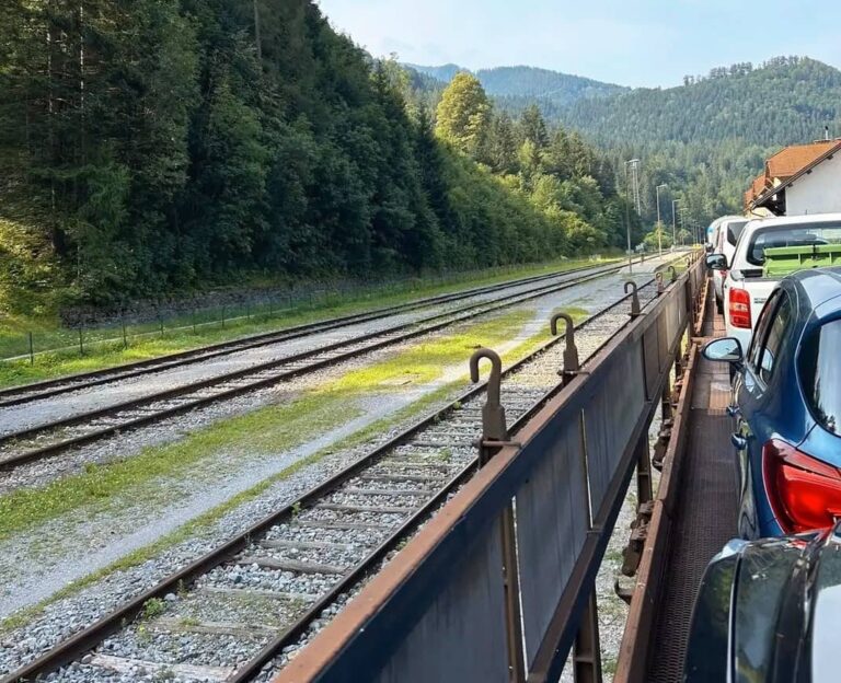 auto und fahrgäste auf dem autozug in slowenien, landschaft und berge im hintergrund