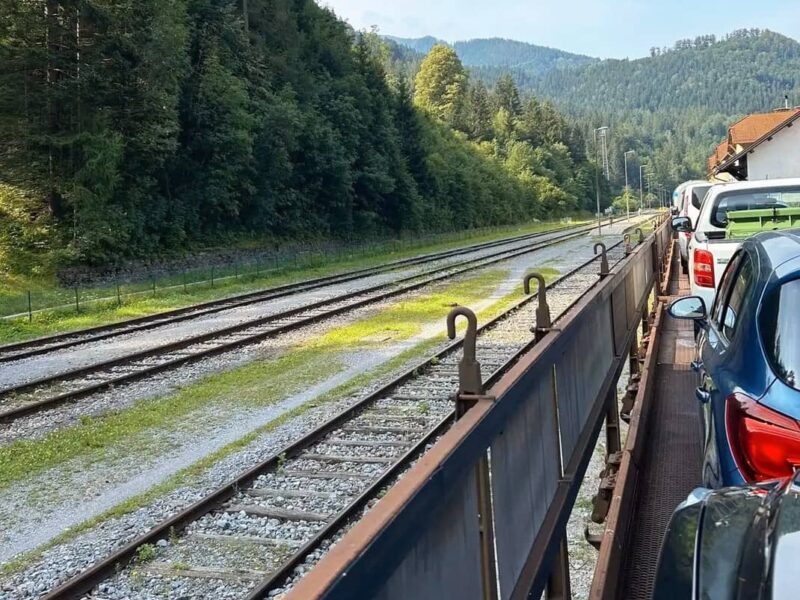 auto und fahrgäste auf dem autozug in slowenien, landschaft und berge im hintergrund