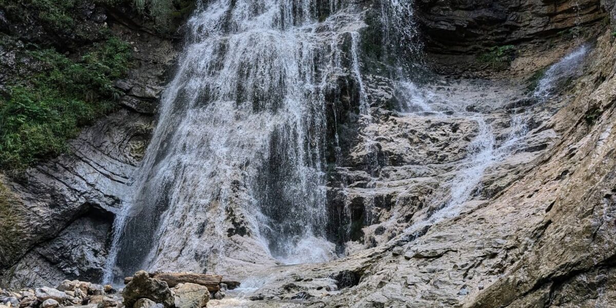 Der Stegovniški wasserfall in Slowenien mit grünem Wald und Felsen